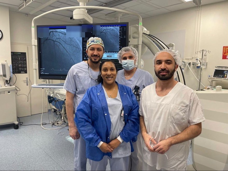L'équipe de cardiologie réunie en salle de cathétérisme, devant les écrans d'angiographie